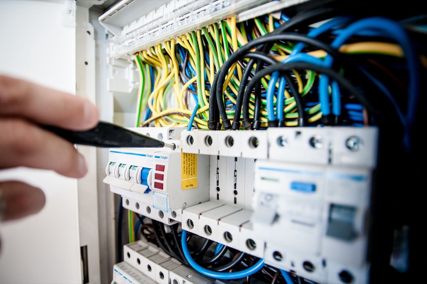 Licensed electrician replacing breakers inside a residential electrical panel