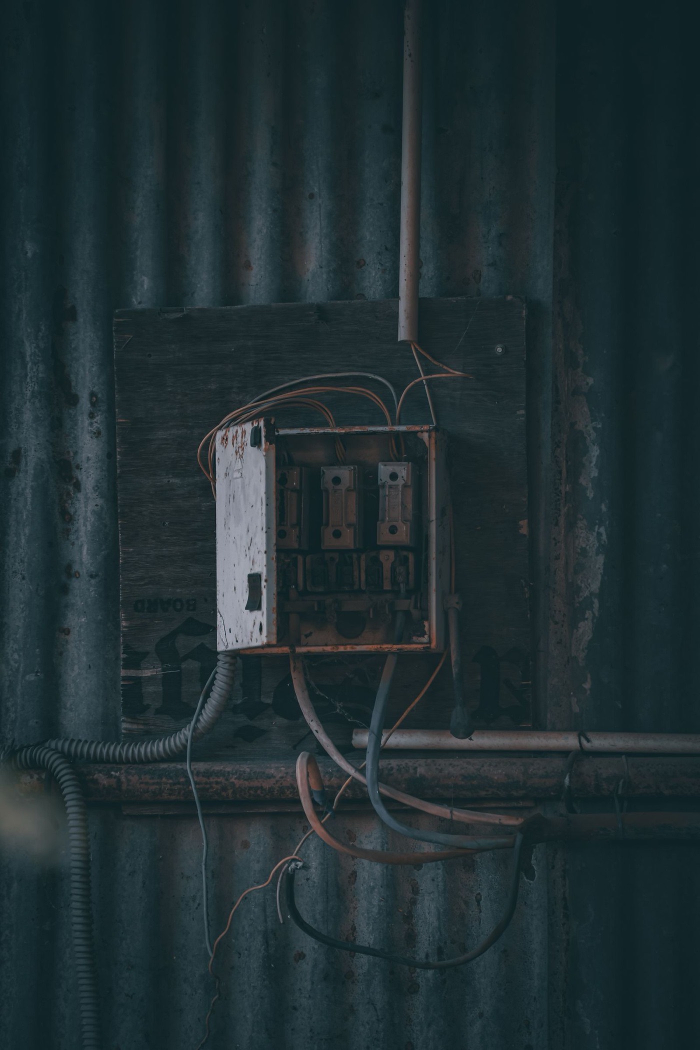 Aging fuse box with exposed wiring, the kind of outdated panel that home inspectors and insurers flag