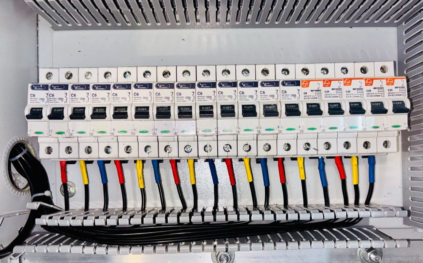 Open electrical panel with neatly organized colour-coded wiring after remediation work